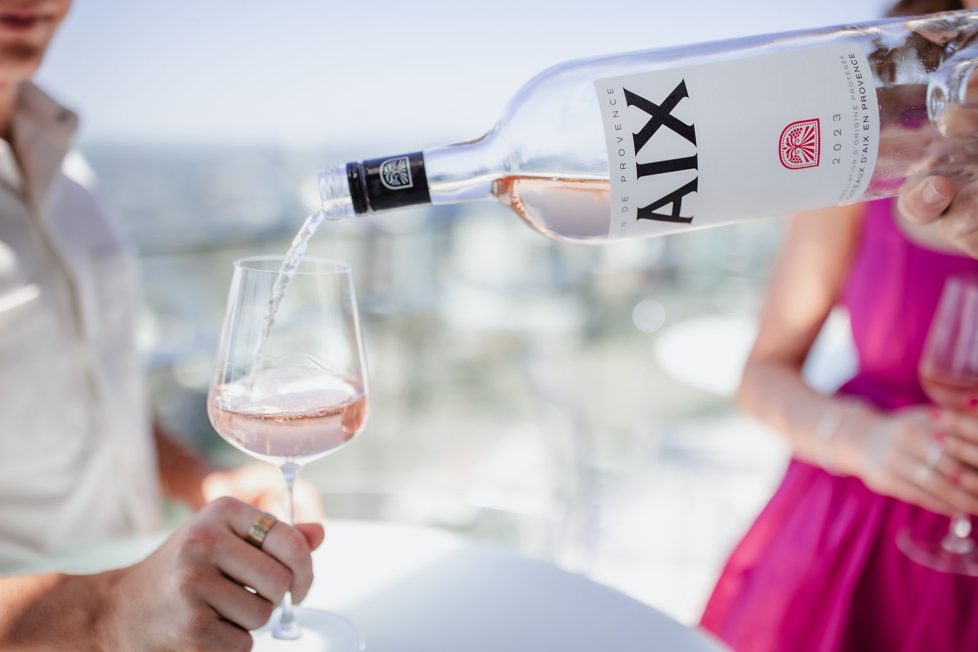Pink rosé wine pouring into wine glass