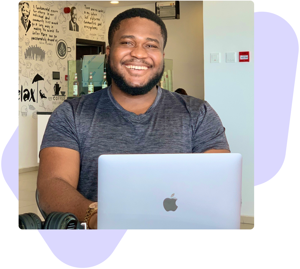a man sitting in front of an apple laptop