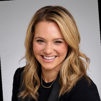 a woman with blonde hair and a black shirt is smiling for the camera .