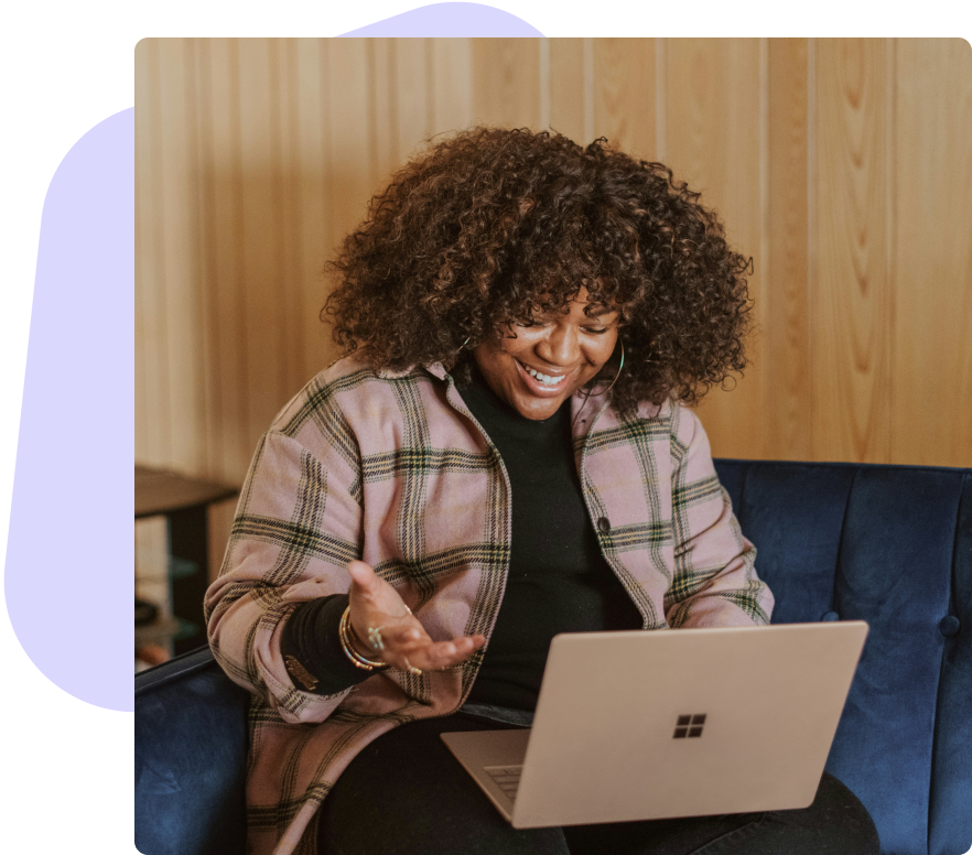 a woman is sitting on a couch using a laptop