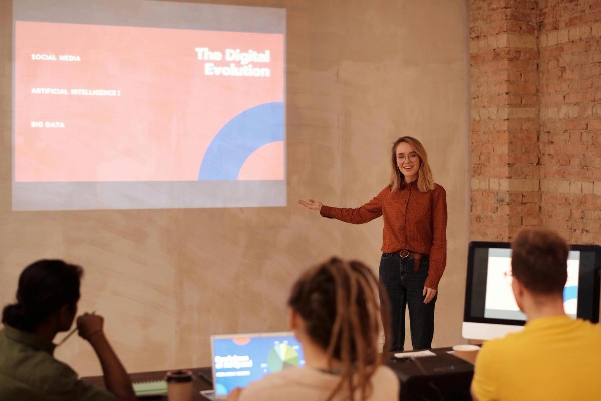 a woman is giving a presentation to a group of people in a conference room .