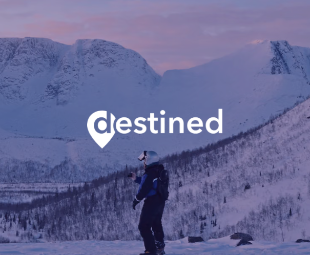A person wearing a VR headset stands in a snowy mountain landscape with the "destined" logo overlaid.