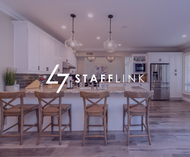 White L7 STAFFLINK logo over a modern kitchen with an island and bar stools.