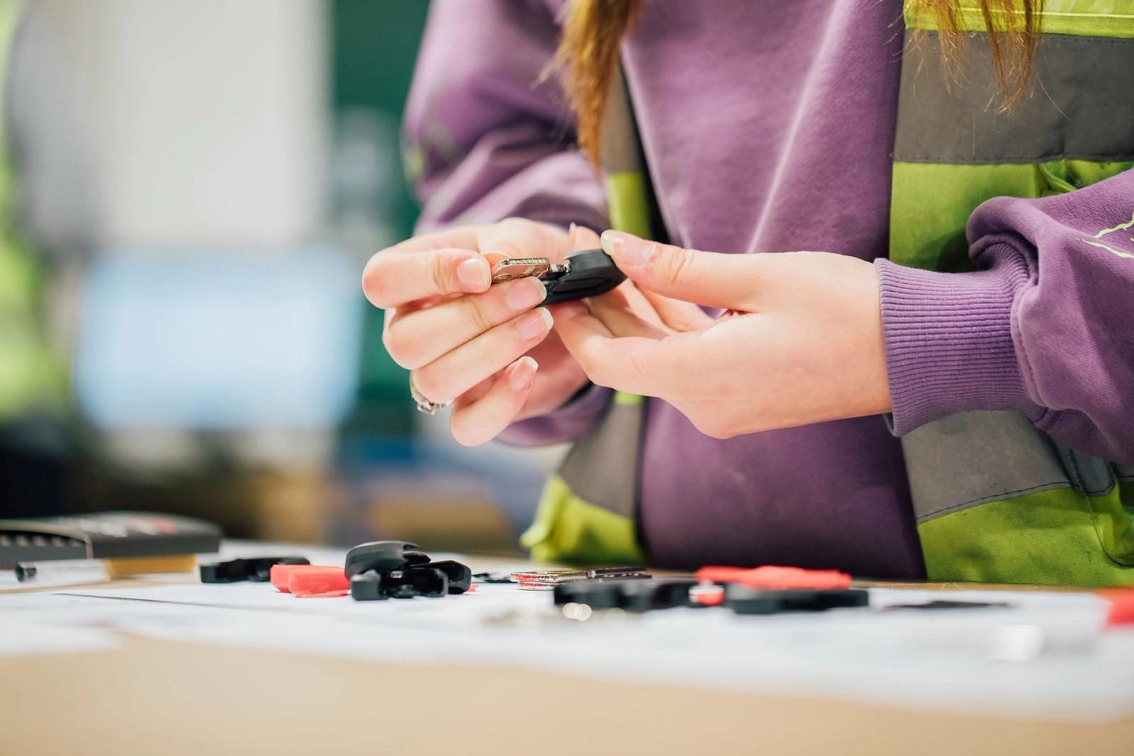 a woman is holding a car key in her hands .