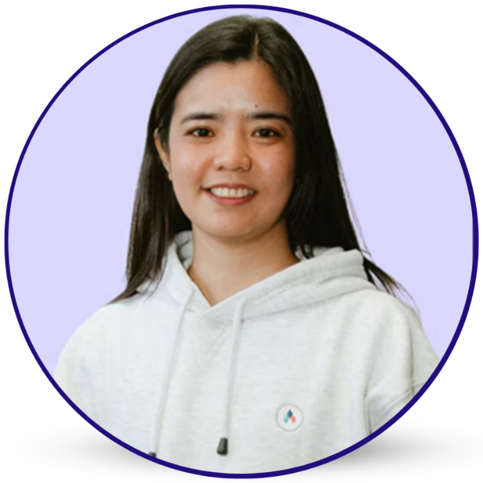 Smiling woman with long dark hair in a gray hoodie.