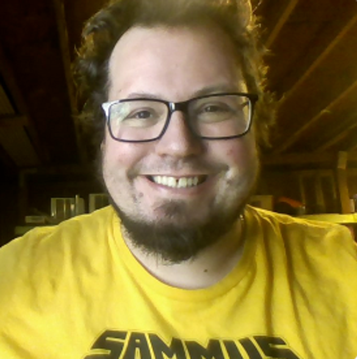 a man wearing glasses and a yellow shirt that says sammies