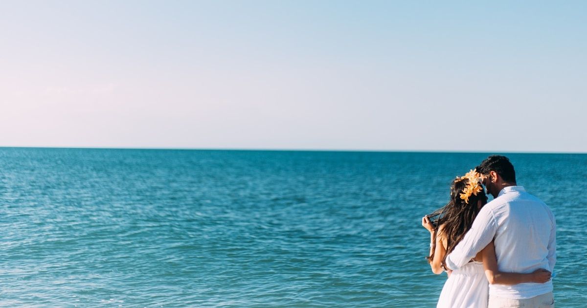 Pareja mirándose y abrazándose frente al mar de Alicante