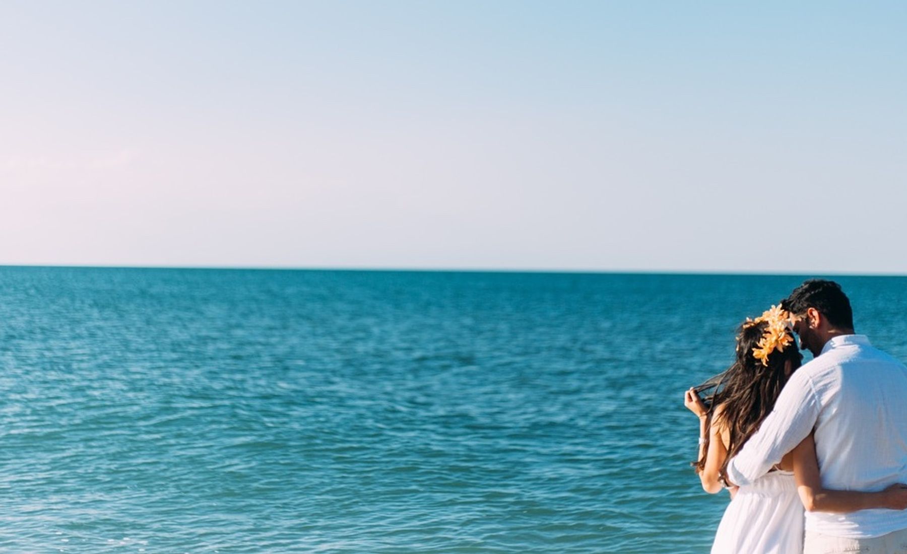 Pareja mirándose y abrazándose frente al mar de Alicante