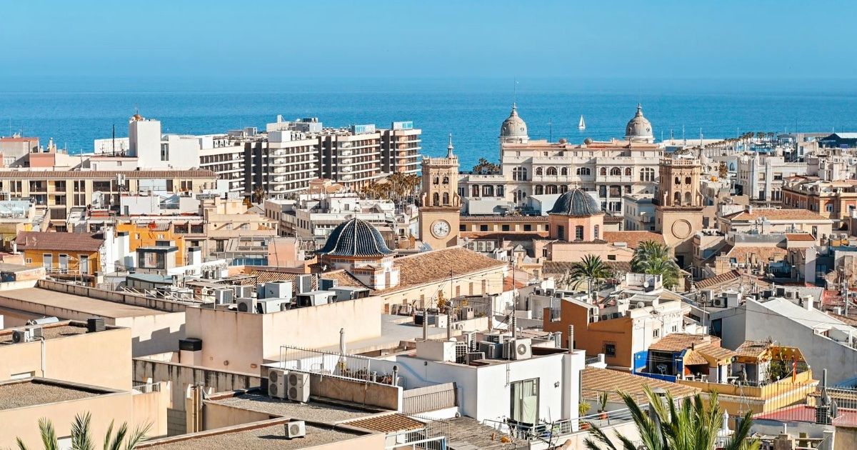 Panorámica de la ciudad de Alicante con edificios blancos y el Mar Mediterráneo al horizonte