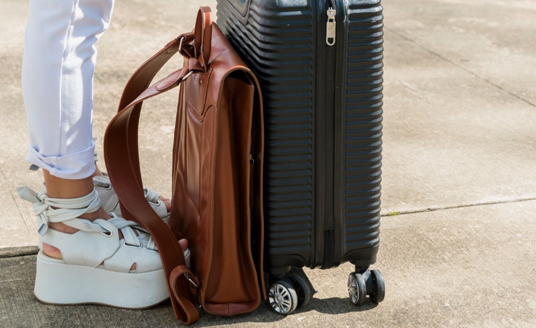 Piernas de chica con maleta antes de viajar a Alicante