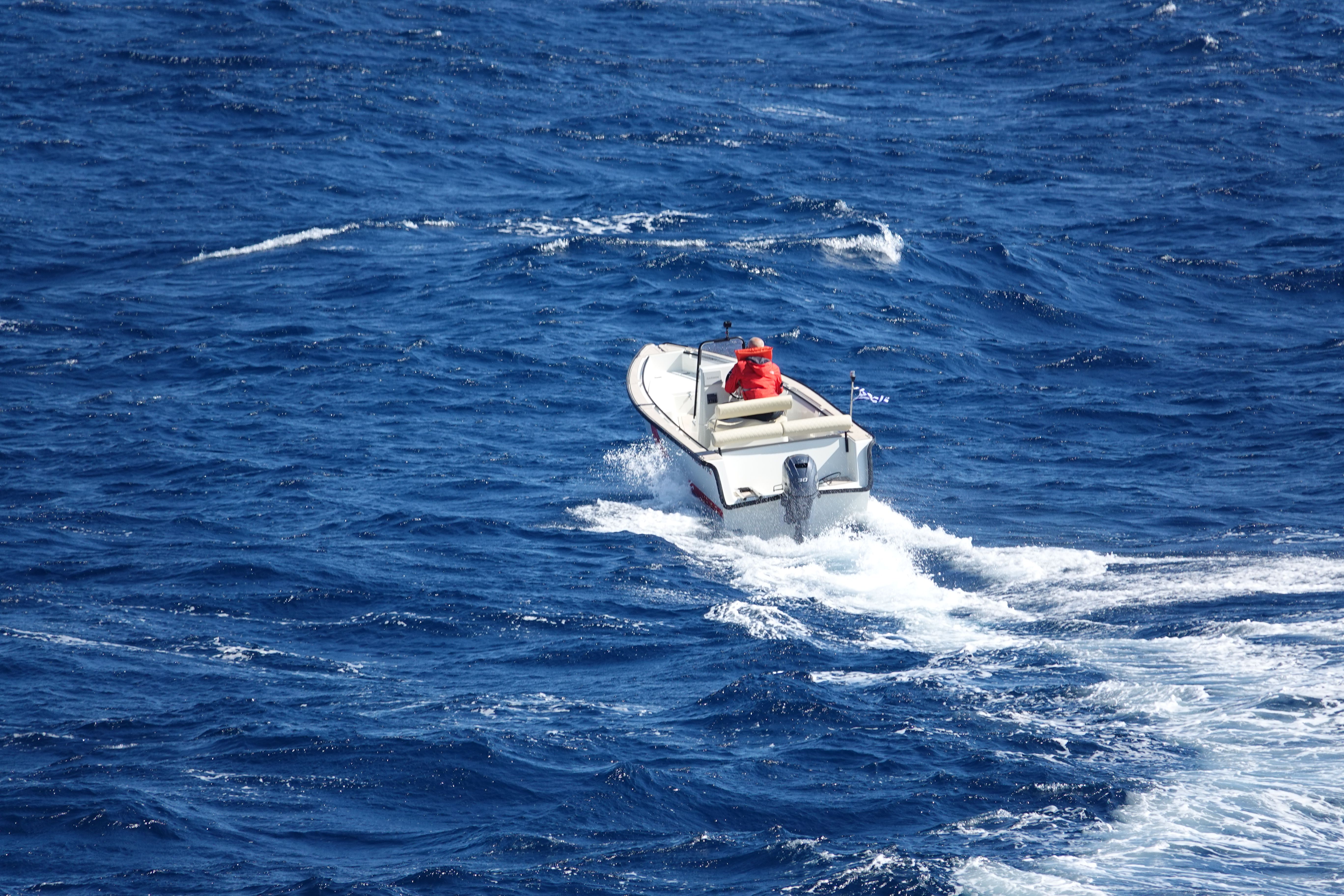 RedFin 49 running through chop, aerial view, driver in an orange life jacket