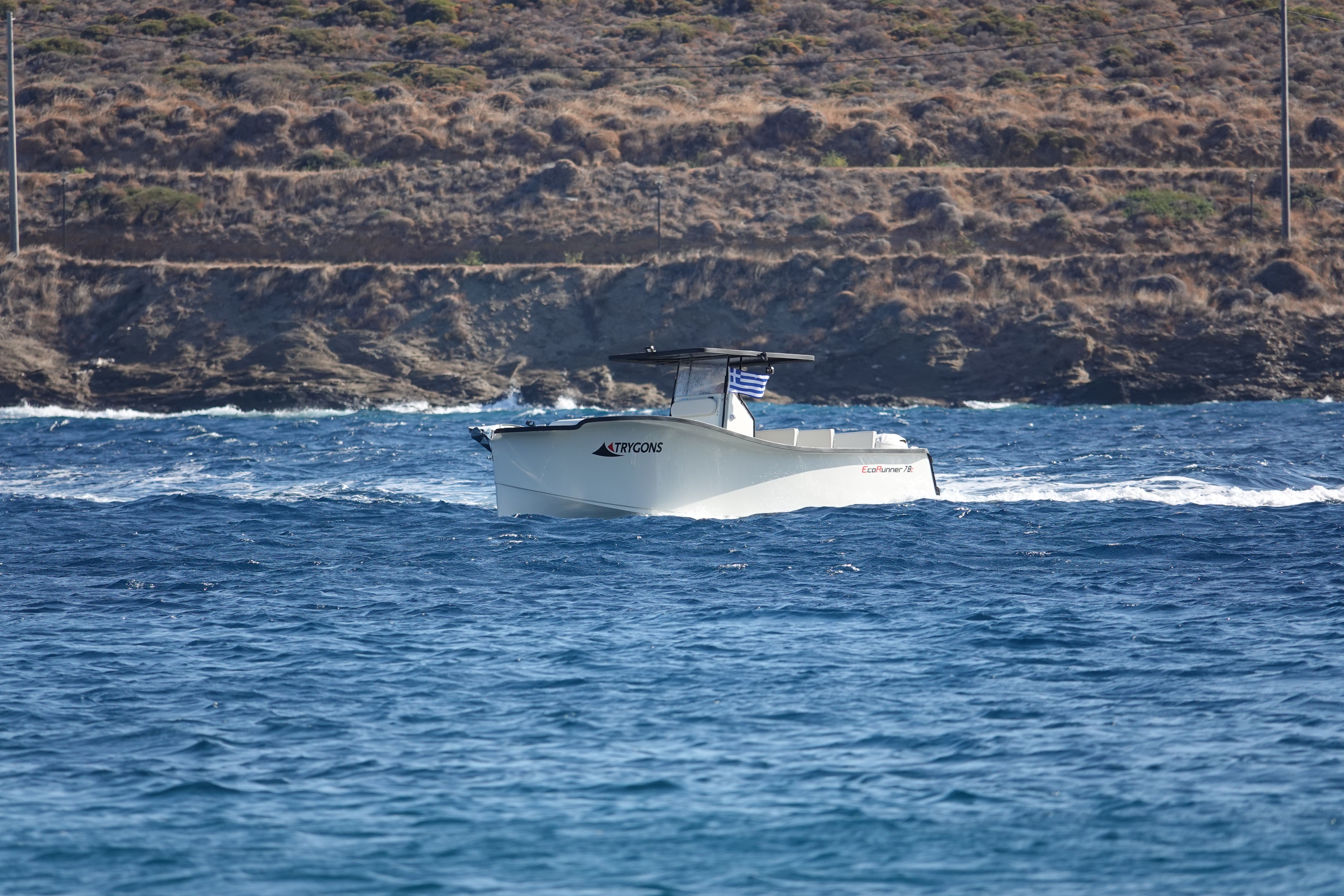 EcoRunner 78 running along the coastline, "EcoRunner 78" legible on the hull