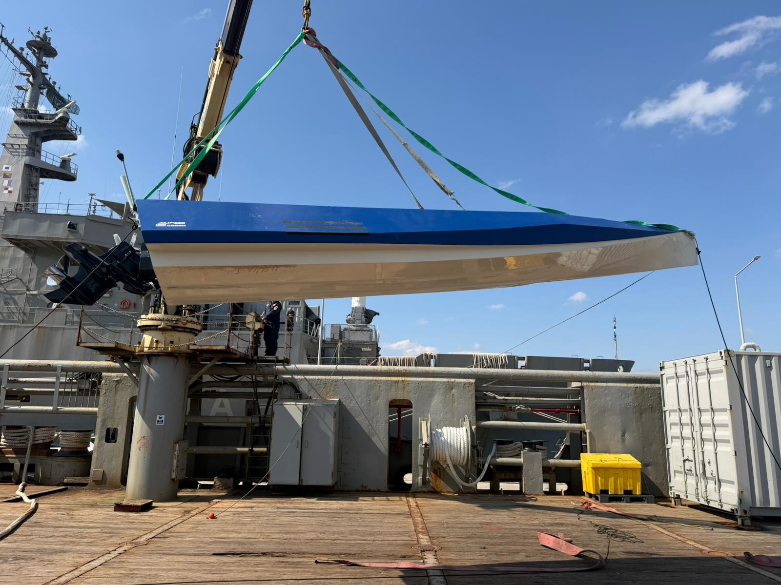 ER69D hull lifted by crane, Mercury outboard and TRYGONS DRONES branding visible