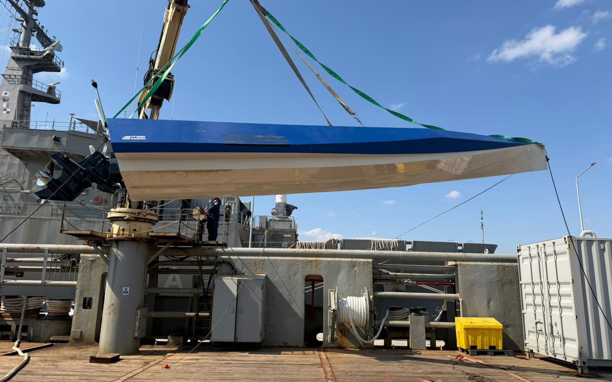 ER69D hull lifted by crane, Mercury outboard and TRYGONS DRONES branding visible