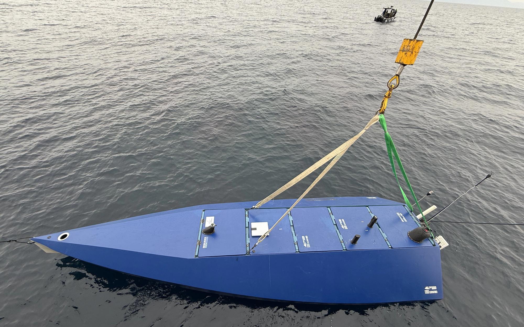 ER69D unmanned surface vehicle lifted from the water by crane during a field trial, dusk