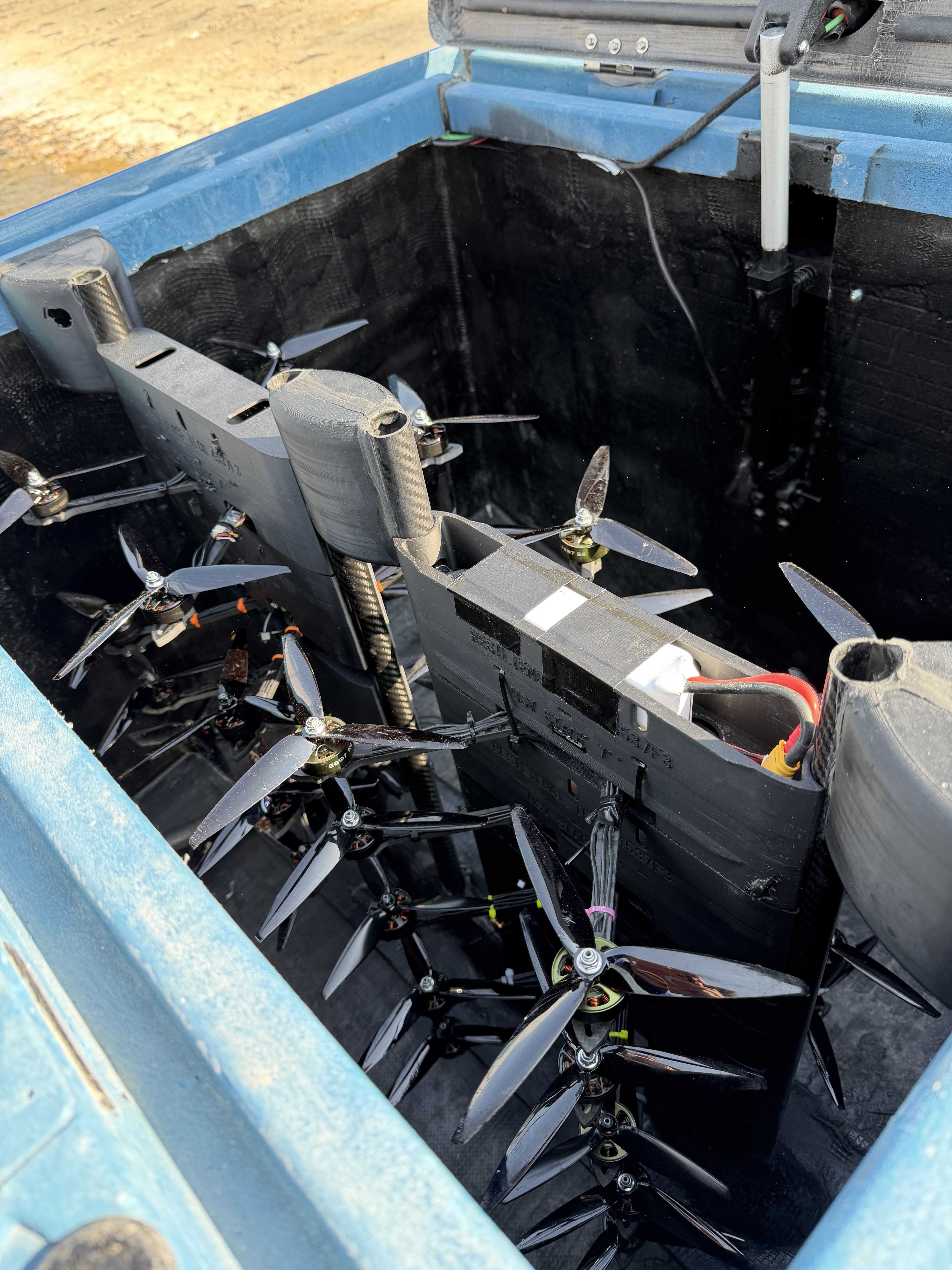 Open hull hatch on the USV showing a stored payload of small multirotor drones