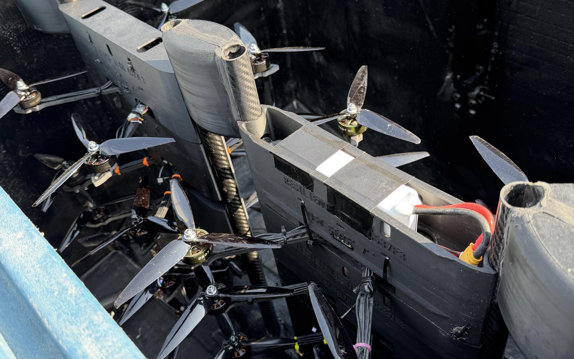 Open hull hatch on the USV showing a stored payload of small multirotor drones