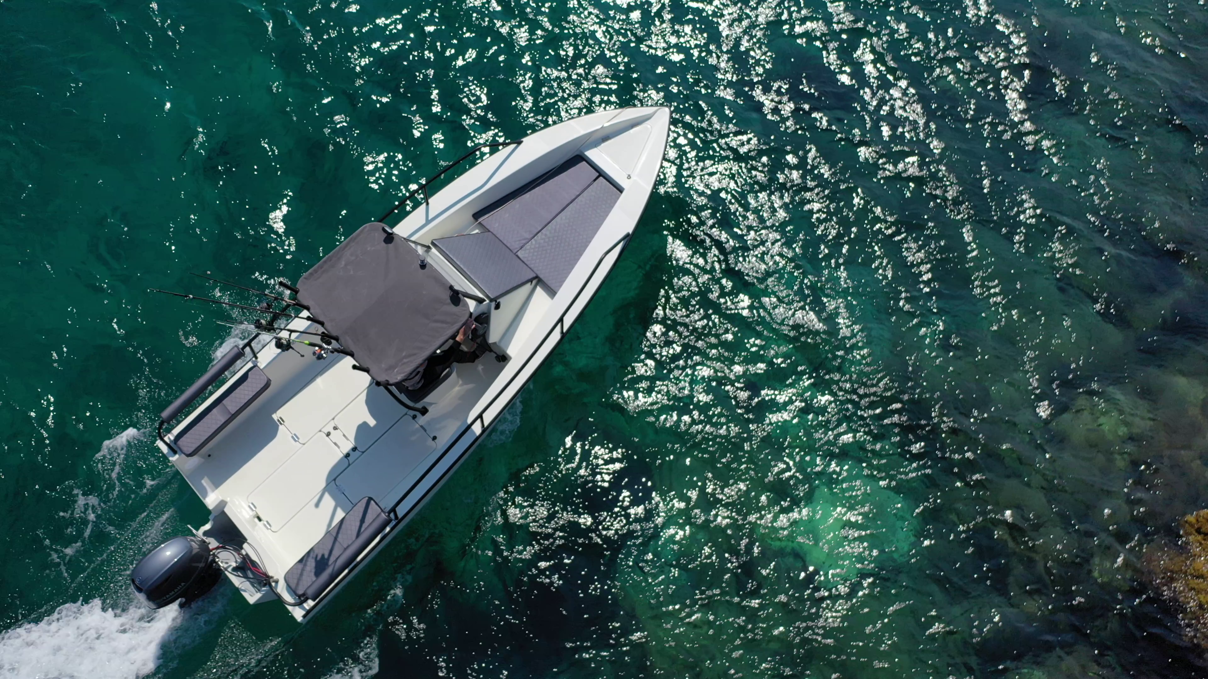 EcoRunner 59 Gen2 running, top-down aerial view over sun-glittered turquoise water