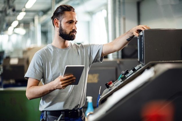 Operator with a tablet next to an industrial machine