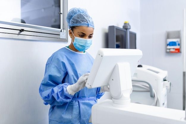 Technician in a clean room operating a medical device workstation