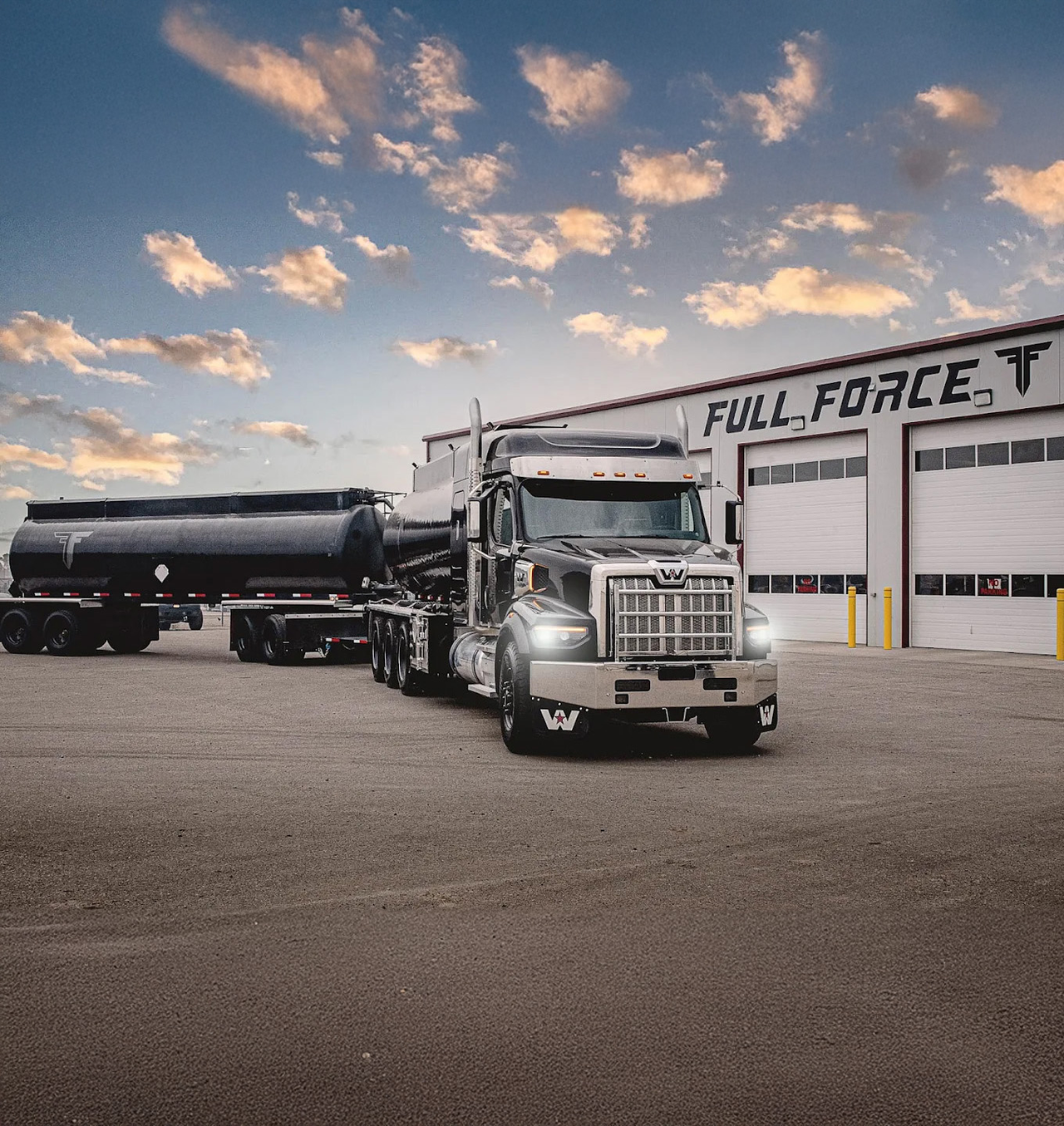 A black and chrome semi-truck is parked in front of a multidoor commercial garage with Full Force Ventures printed across the building.