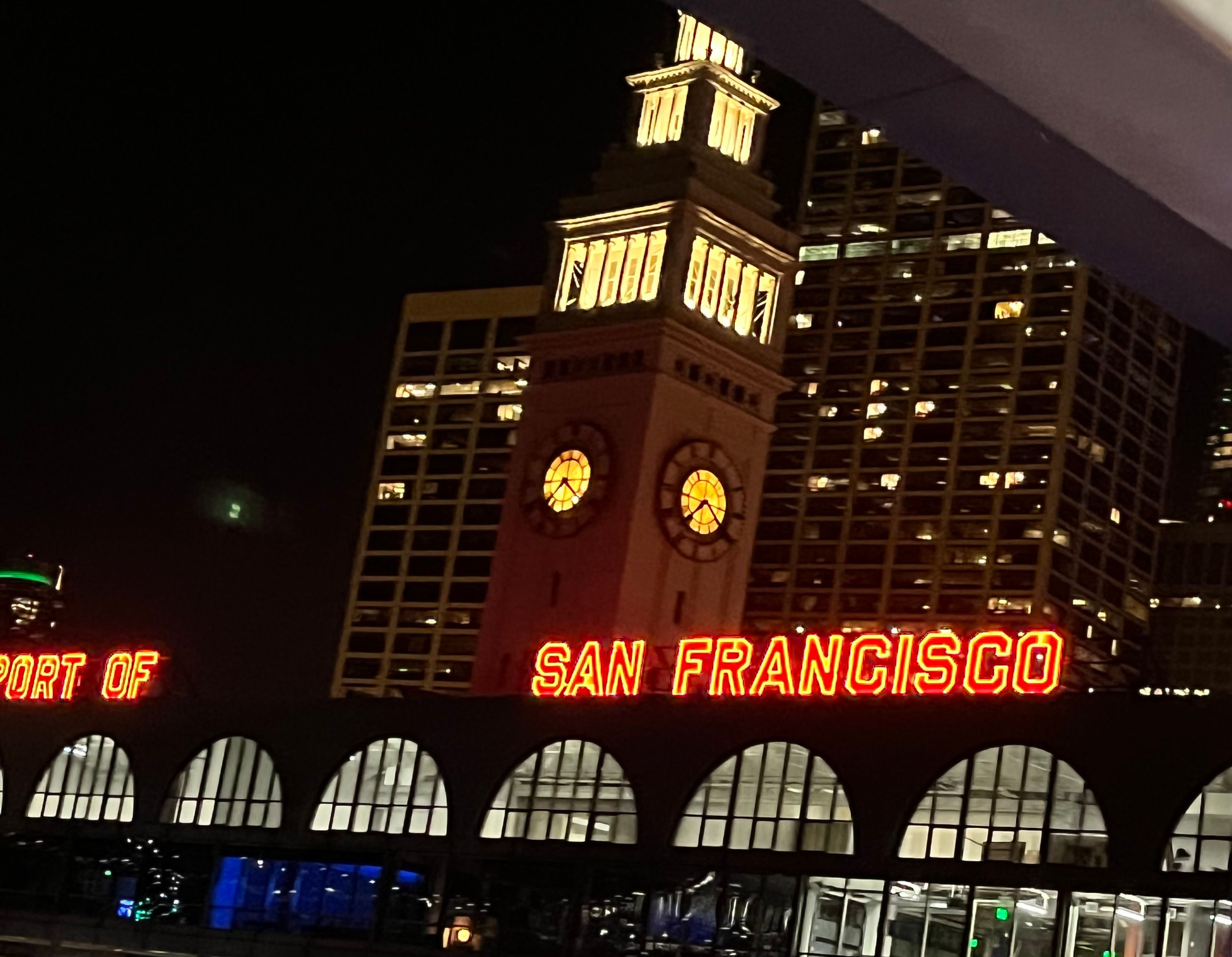 Building with large red neon letters that say Port of San Francisco, in night time
