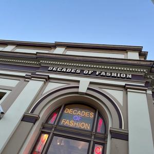 storefront that says decades of fashion in neon