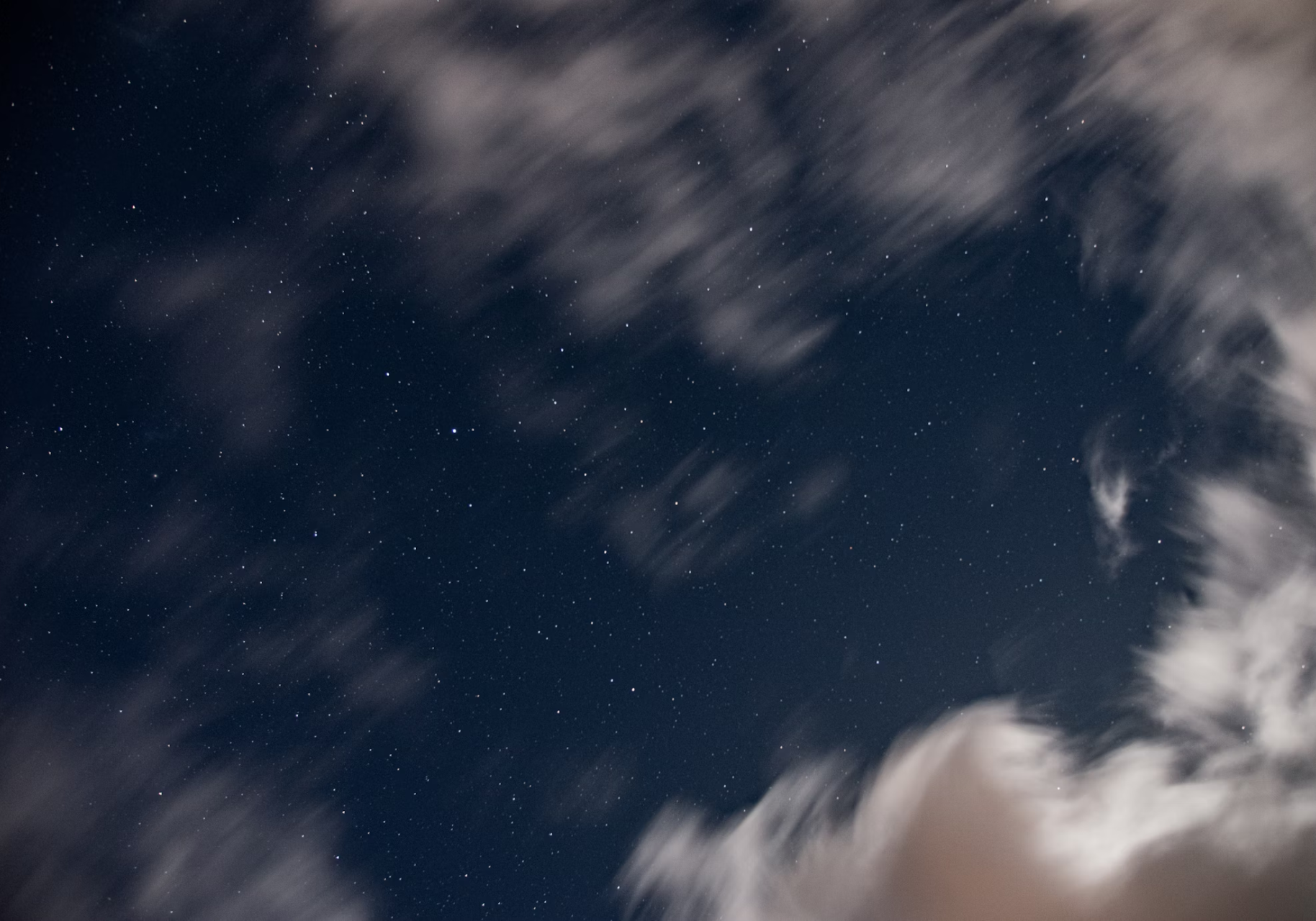 Clouds blurred across the starry night sky