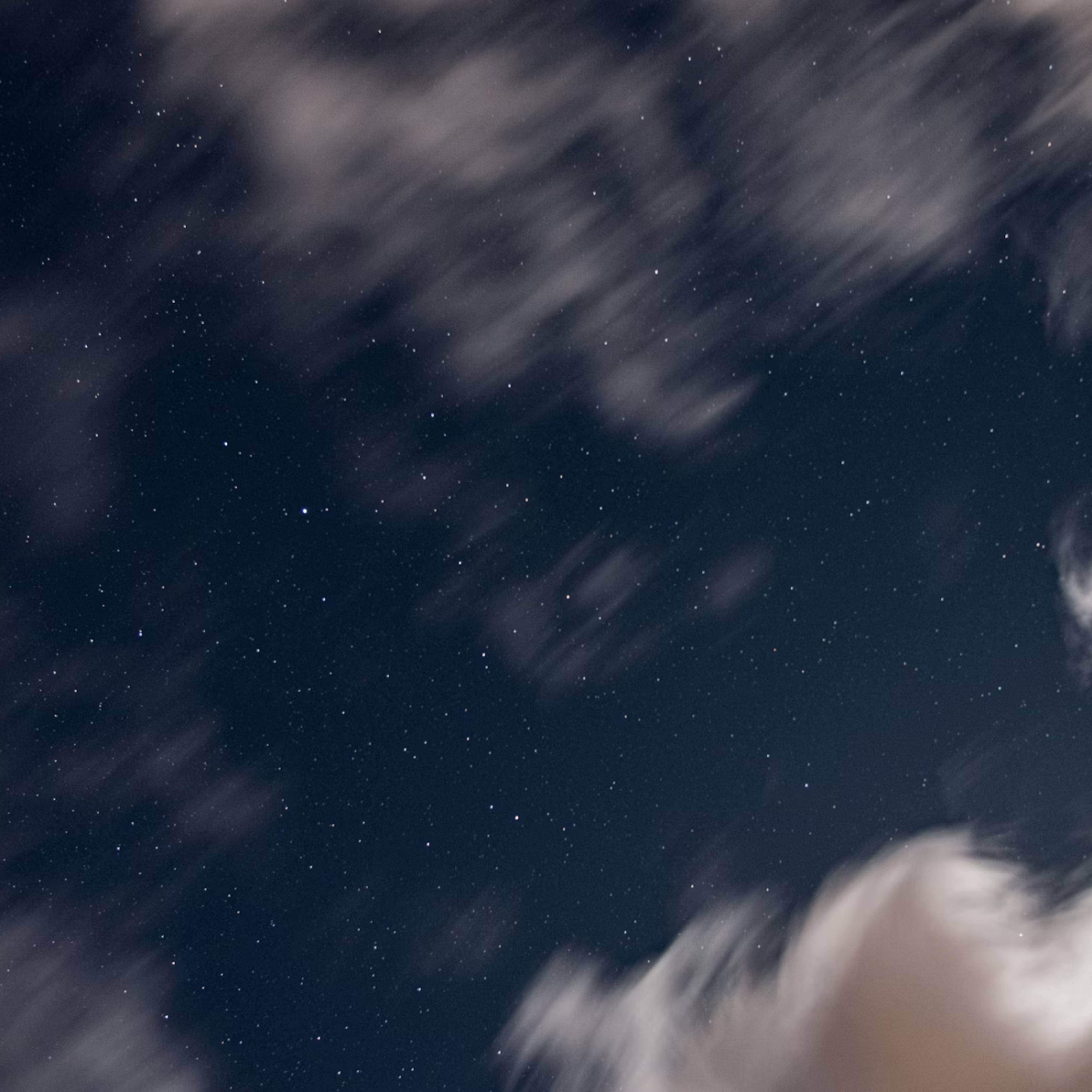 Clouds blurred across the starry night sky