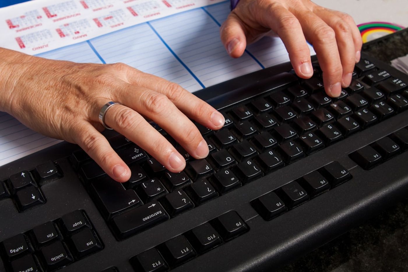 person typing prompts into an AI chat interface on a laptop