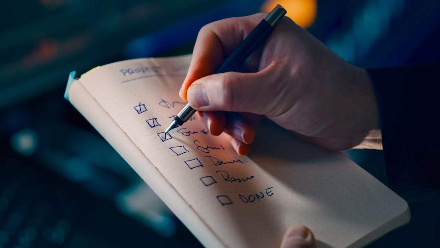 Notebook with a content checklist next to a laptop