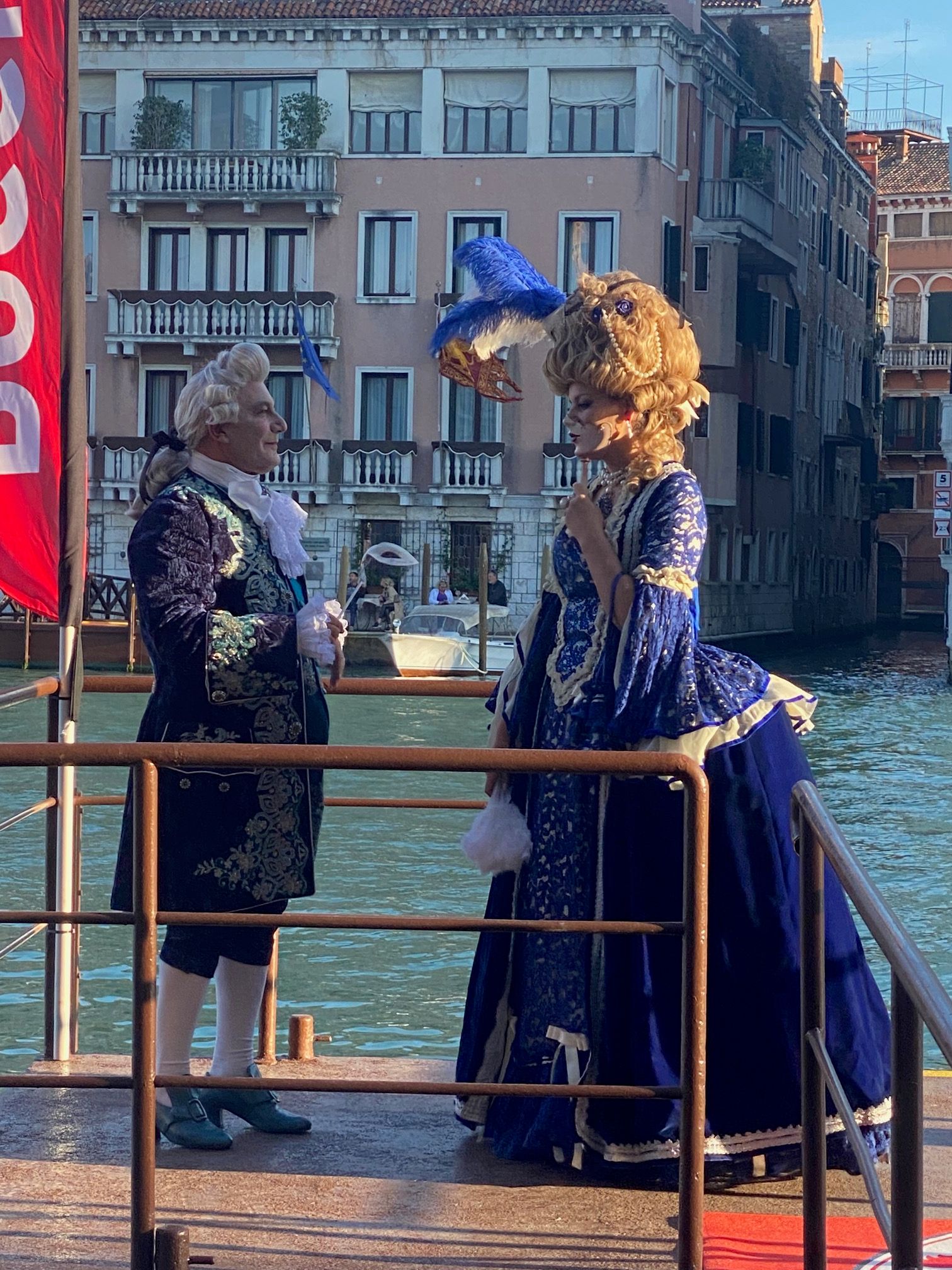 due attori vestiti in tipici abiti veneziani parlano sulla riva del canal Grande di Venezia