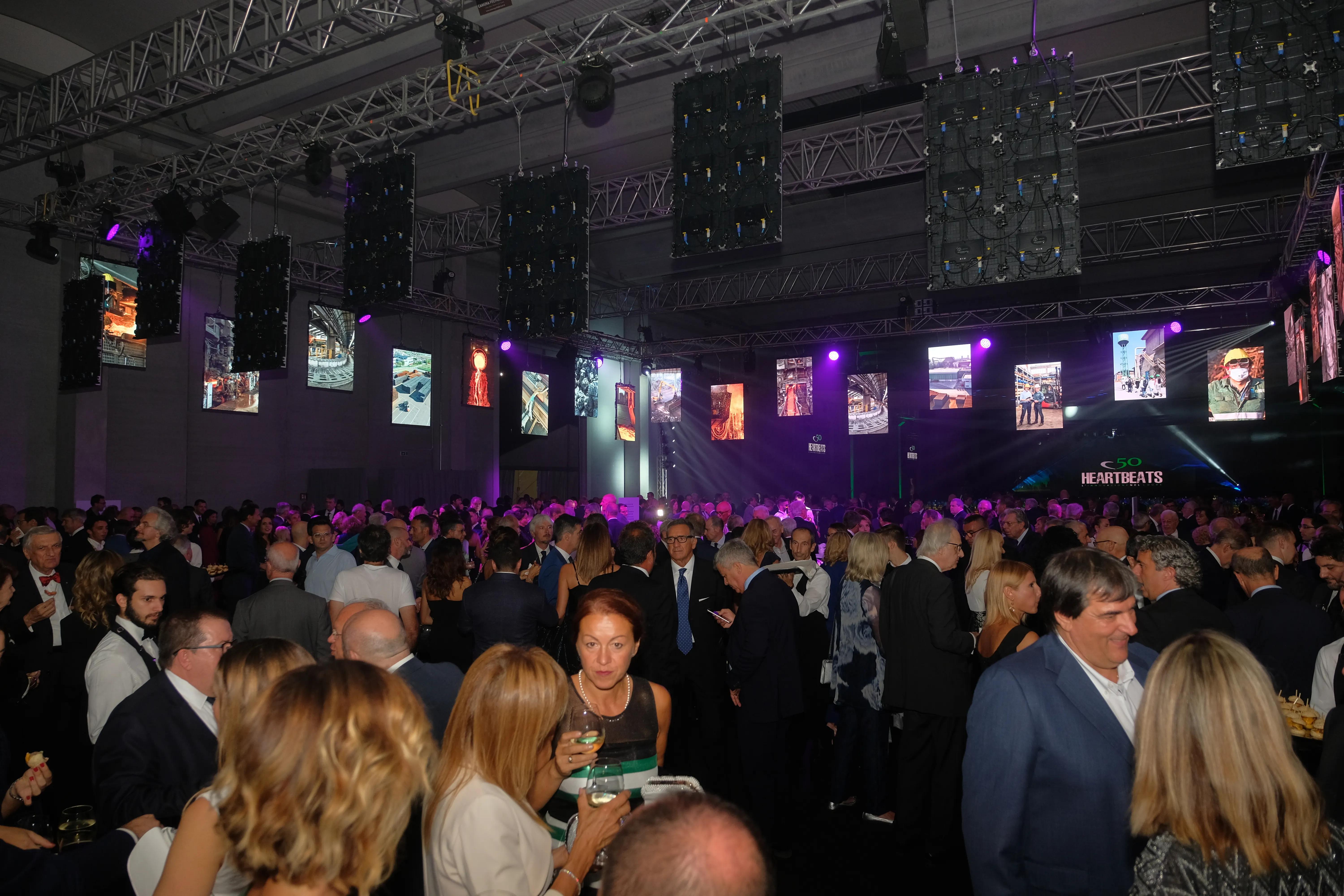 molte persone che mangiano con luci e schermi