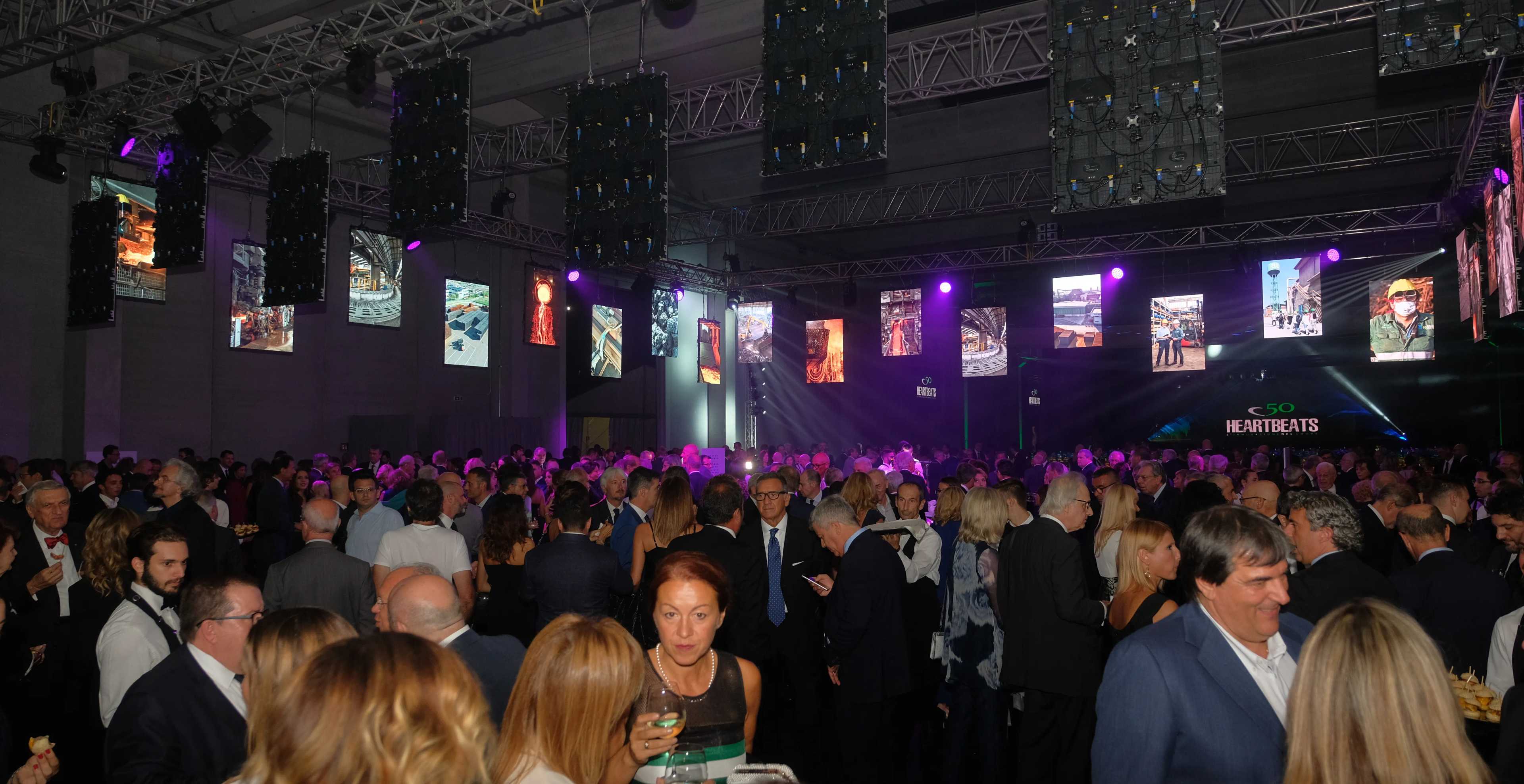 molte persone che mangiano con luci e schermi