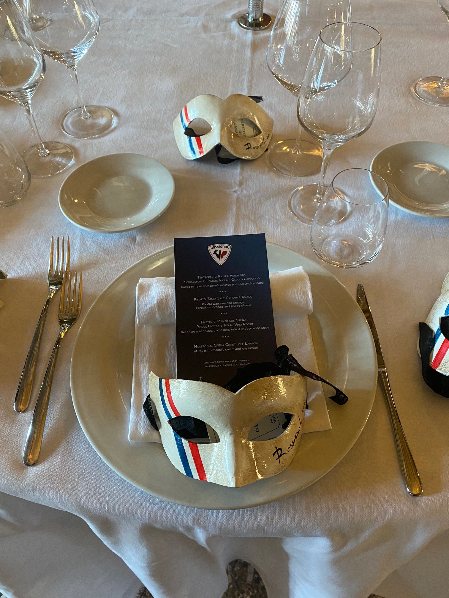 tavola apparecchiata con maschere veneziane e menù con logo rossignol