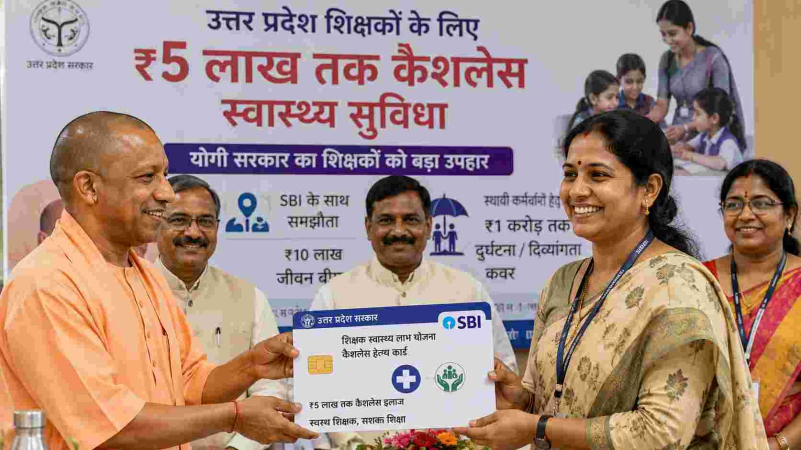 Uttar Pradesh teachers receiving ₹5 lakh cashless healthcare card with SBI insurance benefits announced by the state government.