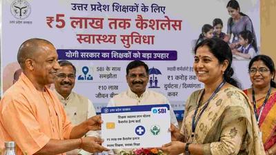 Uttar Pradesh teachers receiving ₹5 lakh cashless healthcare card with SBI insurance benefits announced by the state government.