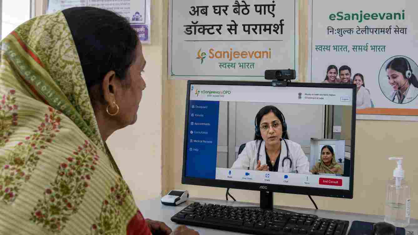 An Indian family using a smartphone to consult a doctor through eSanjeevani from home.