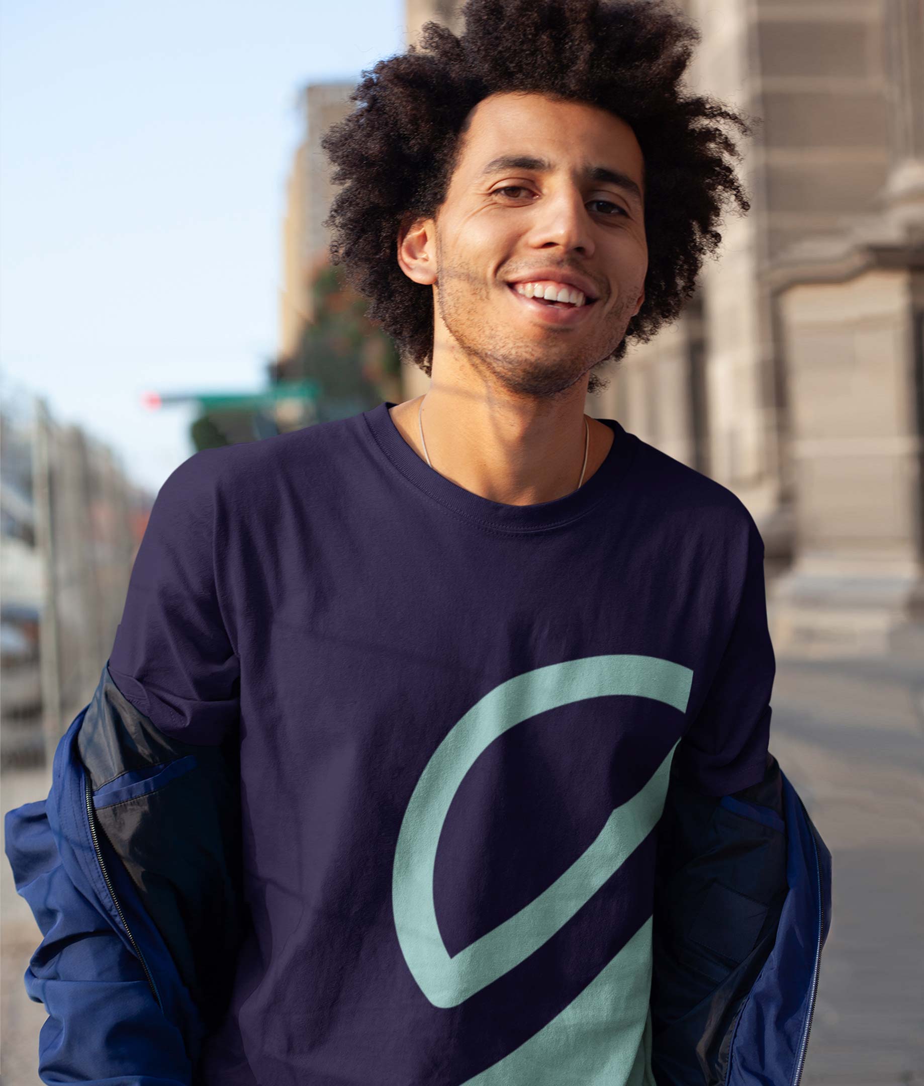 Young millennial man walking down street wearing a Stack branded t-shirt.