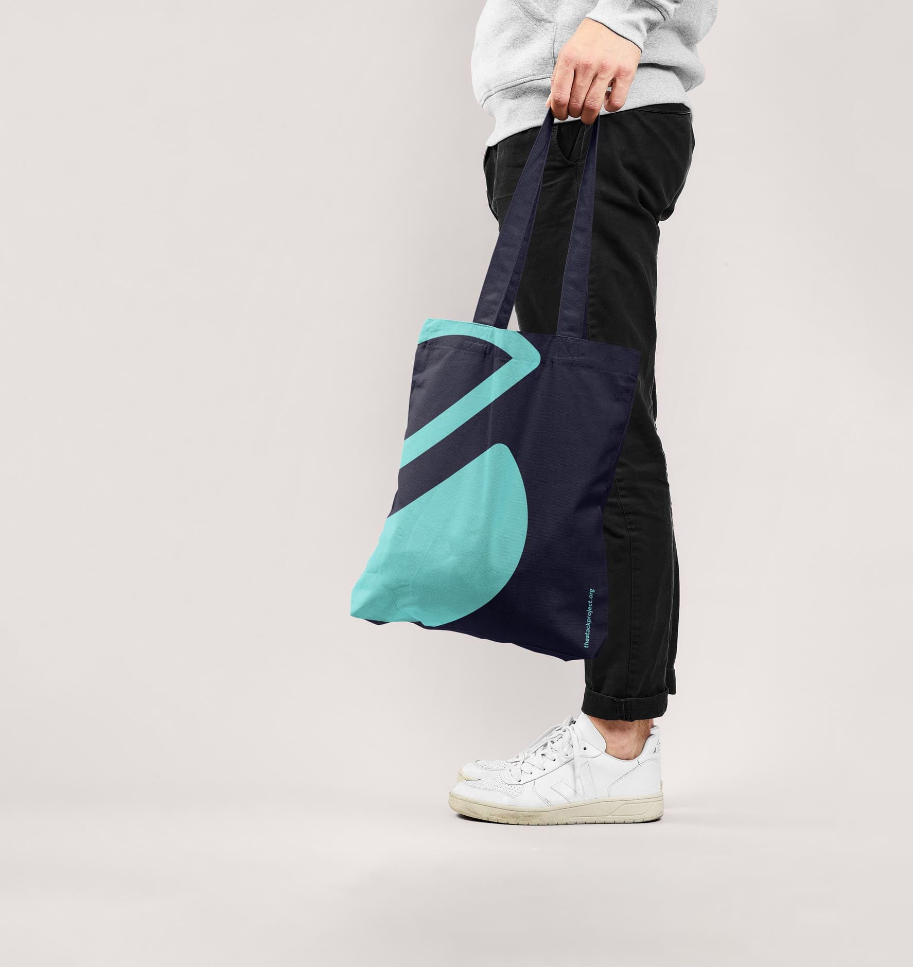 Man in a photography studio holding a Stack tote bag.