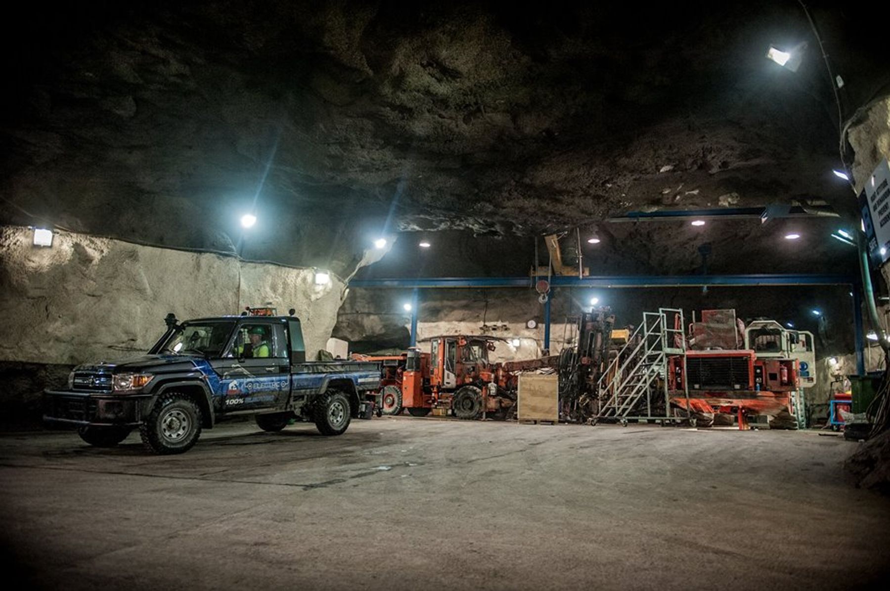 Tembo 4x4 e-LV electric Land Cruiser 70 series ute parked in an underground mine beside orange drilling rigs