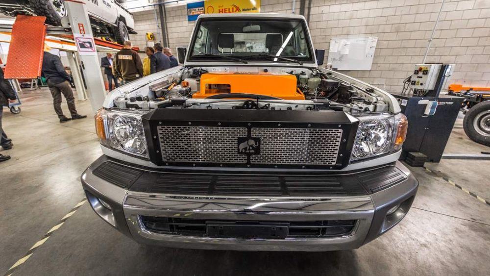 Front of a Tembo 4x4 e-LV Land Cruiser with bonnet open, showing the orange electric drive unit and elephant grille badge