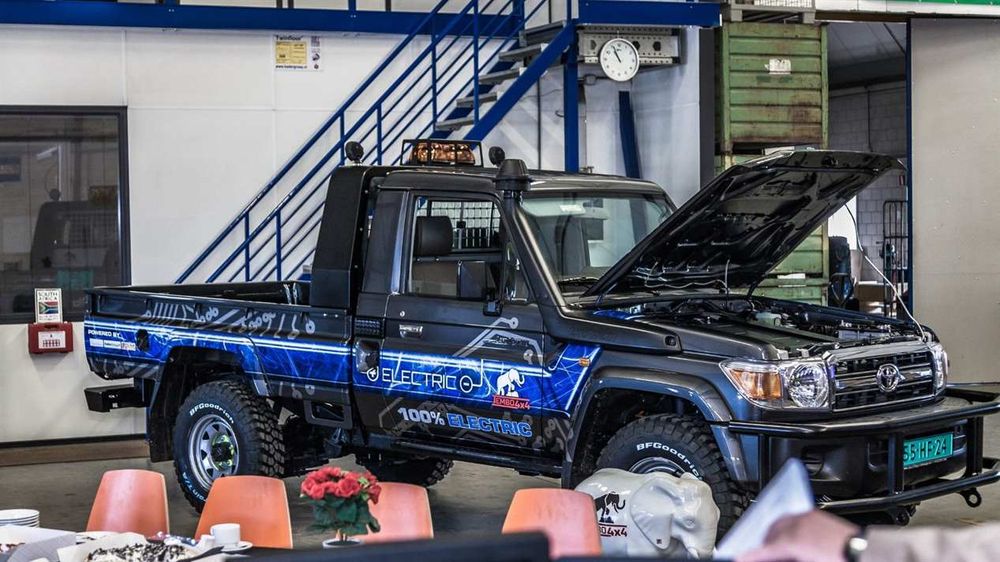 Tembo 4x4 Electric Cruiser single-cab Land Cruiser 70 series with bonnet open, displayed in the workshop beside guest tables