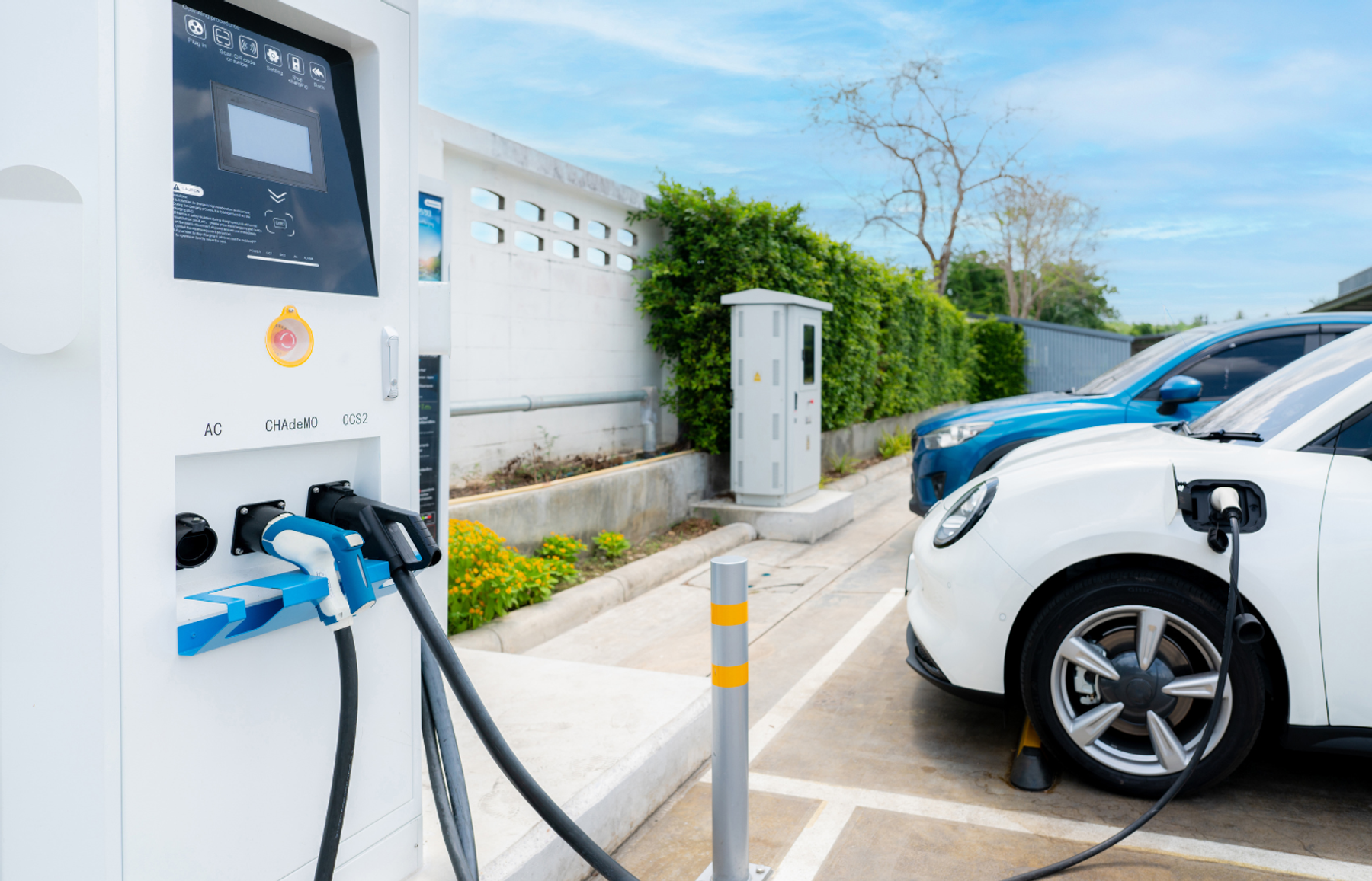 Electric car plugged in at a car park charging station with AC, CHAdeMO and CCS2 connectors