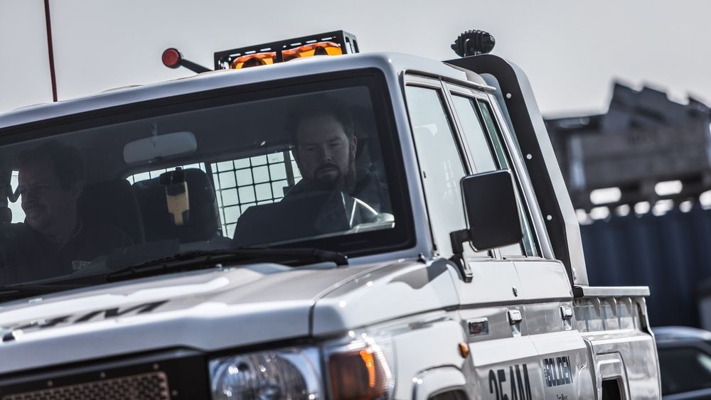 Driver and passenger in the cab of a Tembo 4x4 e-LV with roof beacons and Boliden decals during a test drive
