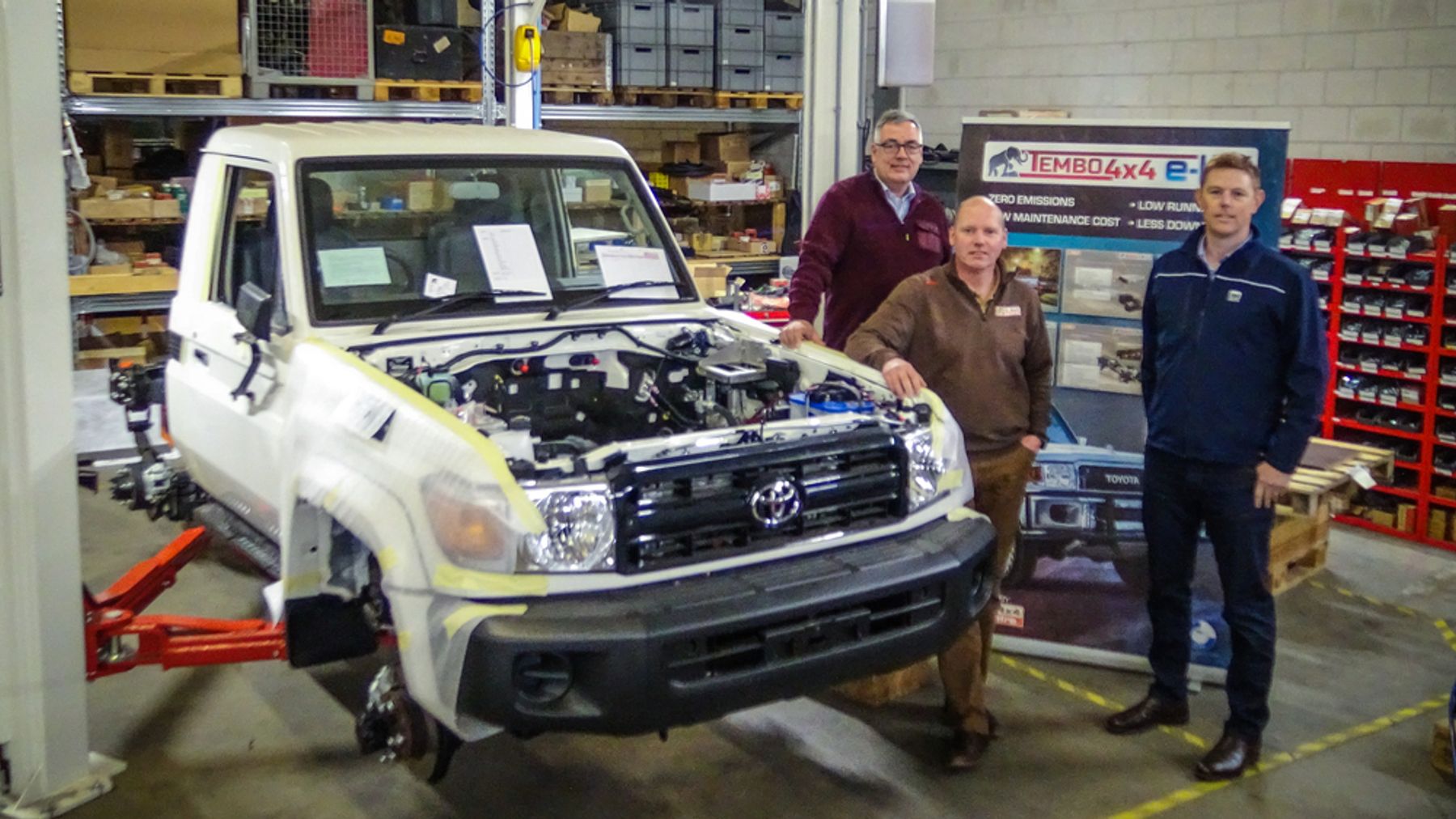 Alexander Haccou and Frank Daams of Tembo with Bill Dunlop of GB EV beside a Land Cruiser 70 series under conversion