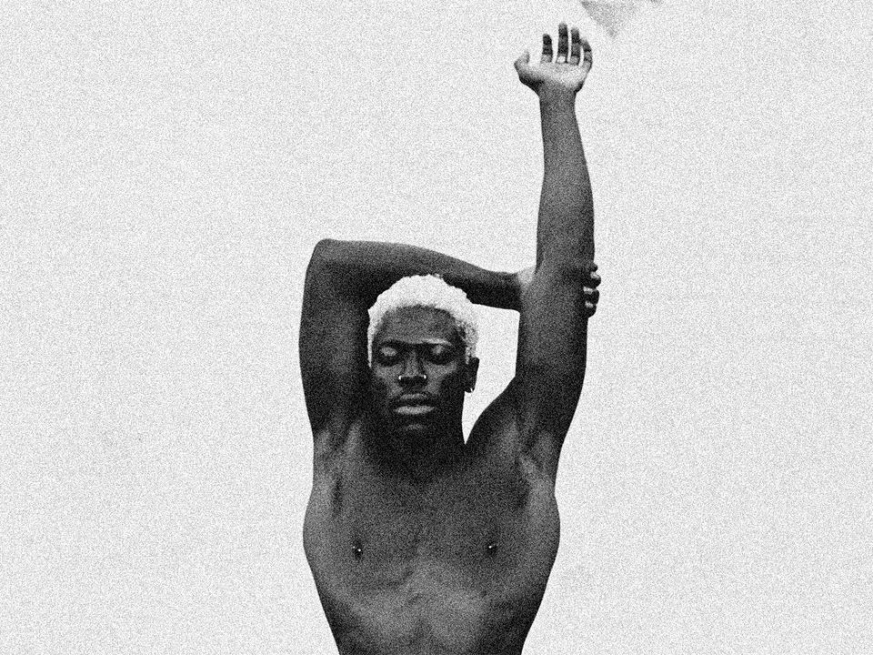 A top-less Moses poses with arms outstretched above his head.