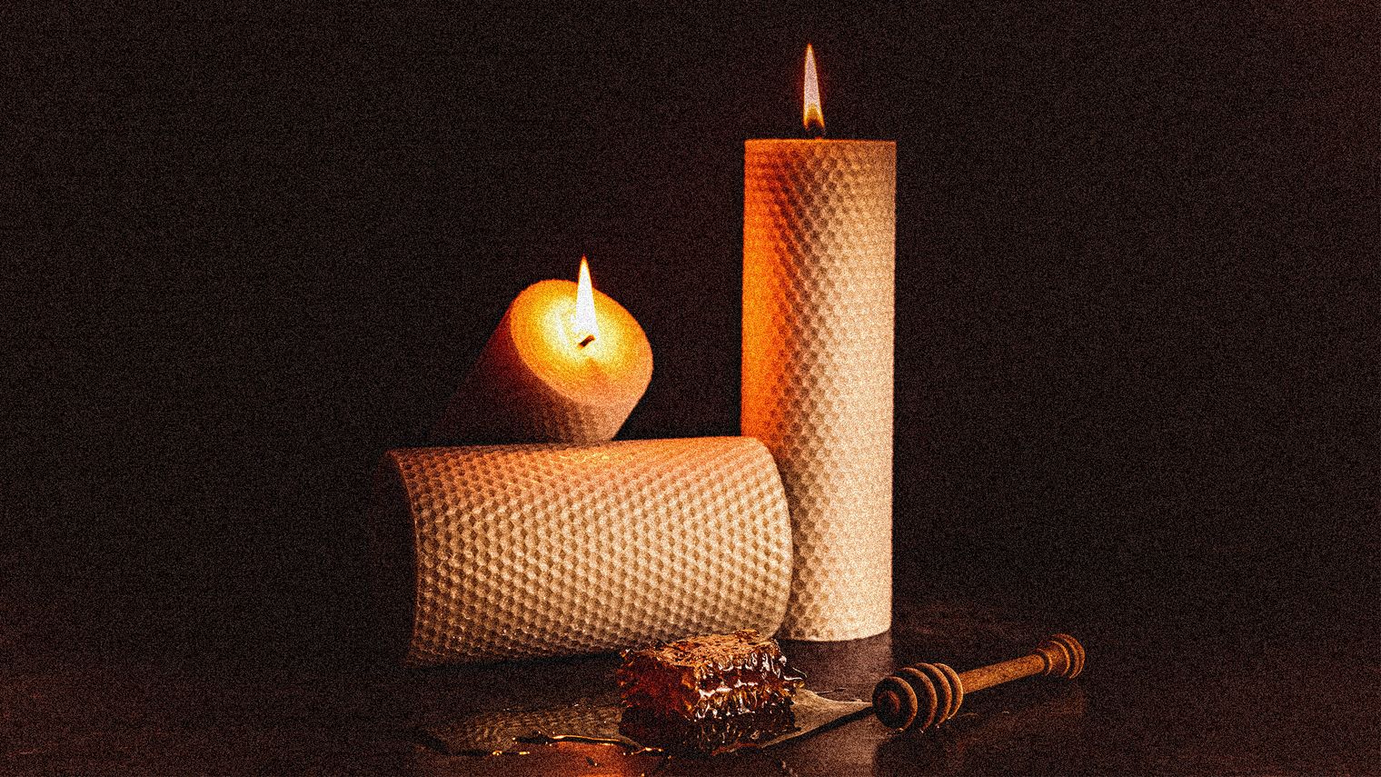 Beeswax candles and honeycomb artistically placed on a table. 