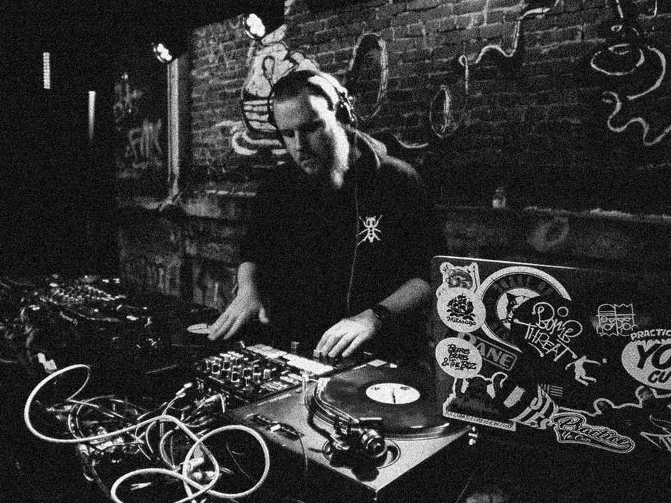 DJ Mad performs on a DJ setup.