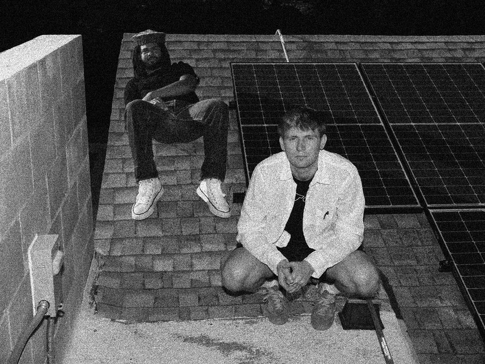 Injury reserve sits on top of a roof, tiles and solar panels are near them.